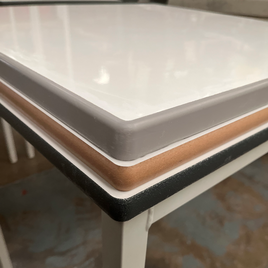 Stack of 3 dry wipe, whiteboard table tops showing a choice of edge: lacquered MDF, sprayed PU and cast PU