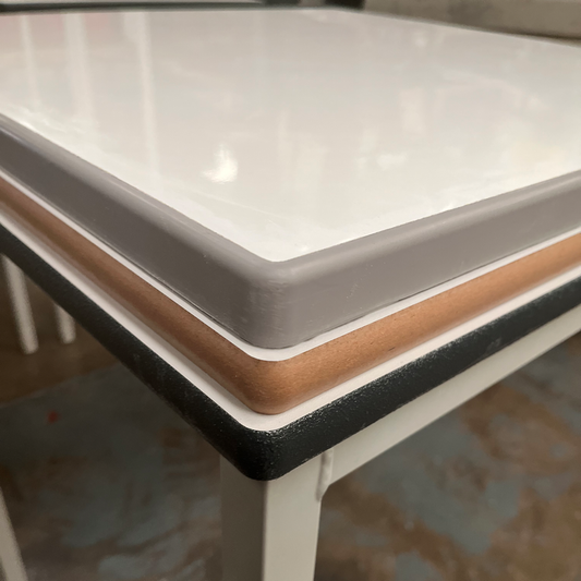 Stack of 3 dry wipe, whiteboard table tops showing a choice of edge: lacquered MDF, sprayed PU and cast PU